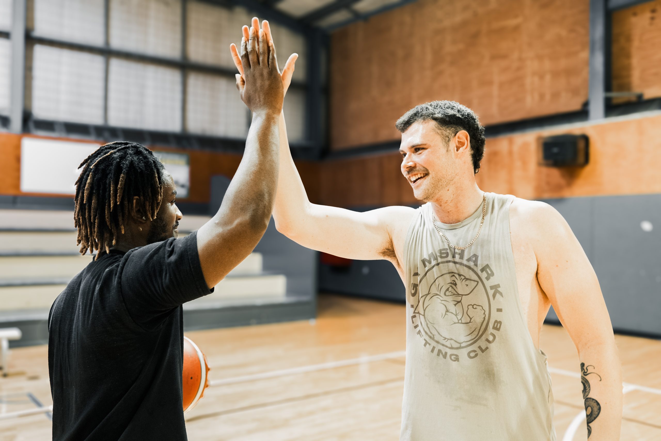 Two friends high five after playing basketball