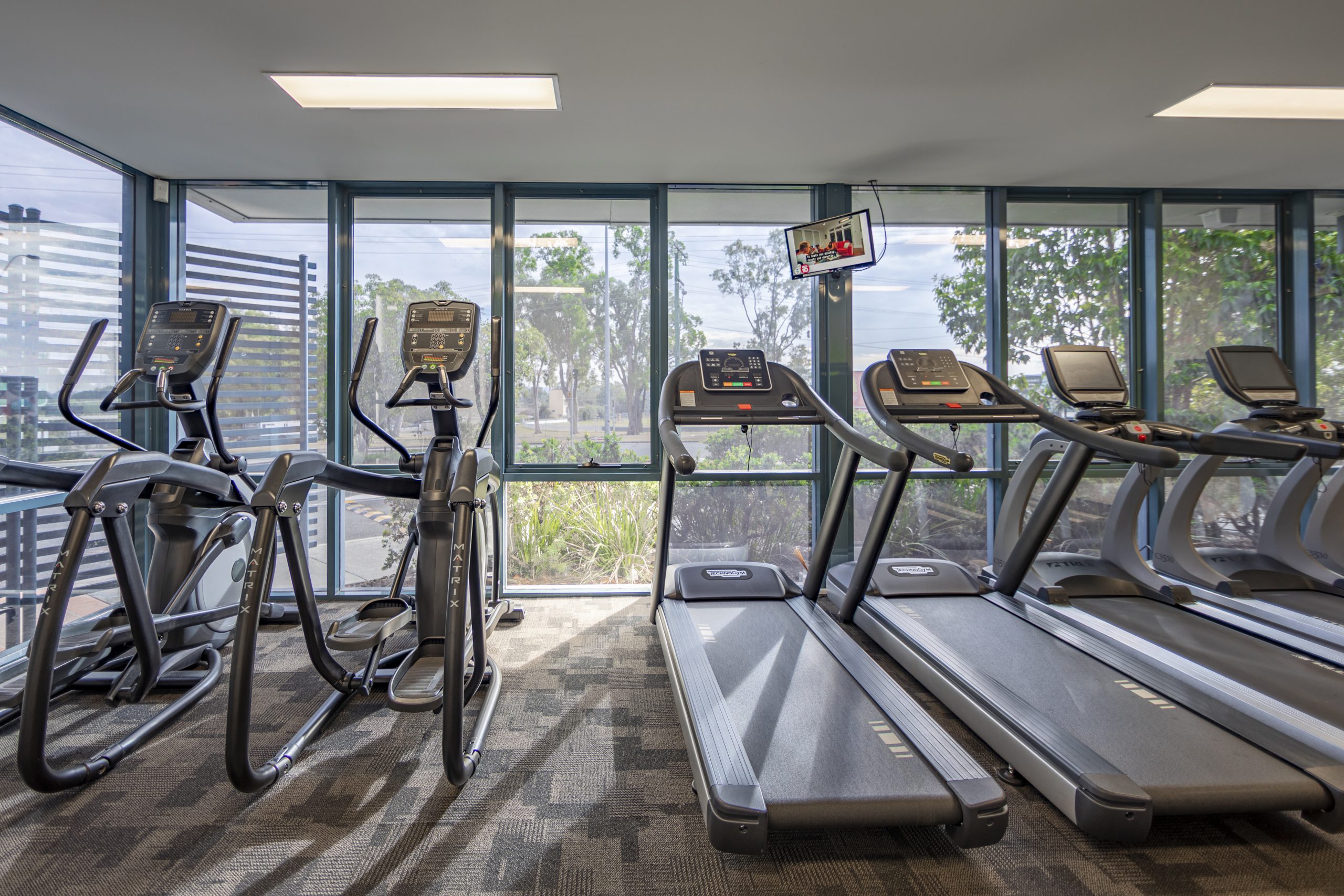 View of treadmills lined up looking out window